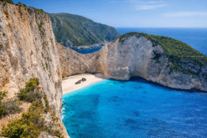 Navagio Beach in Zakynthos Greece with shipwreck surrounded by cliffs and bright blue water